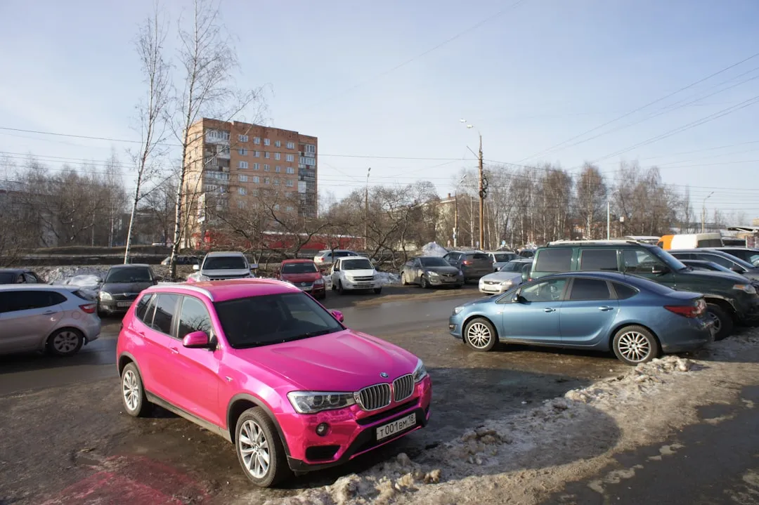 A bright pink car parked in a lot