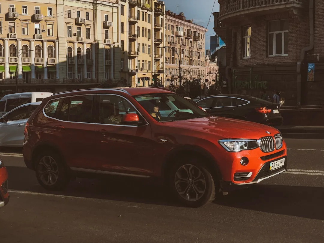 orange BMW X3 SUV on road