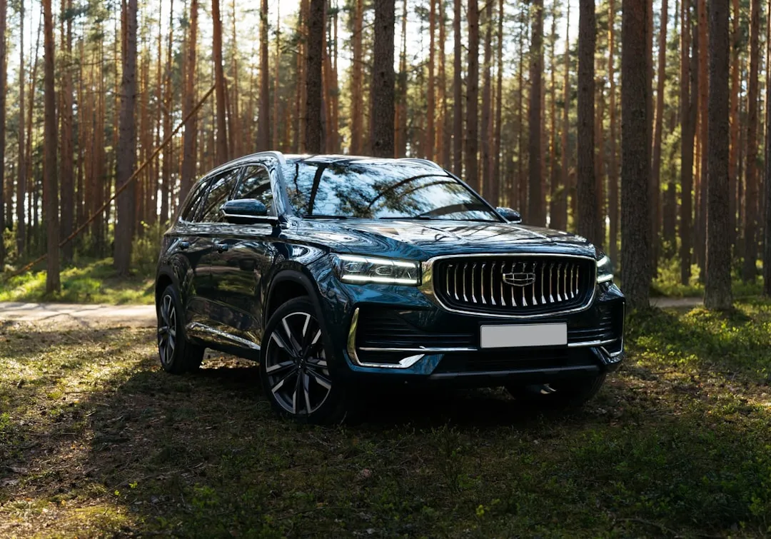 Dark blue suv parked in a sunlit forest.