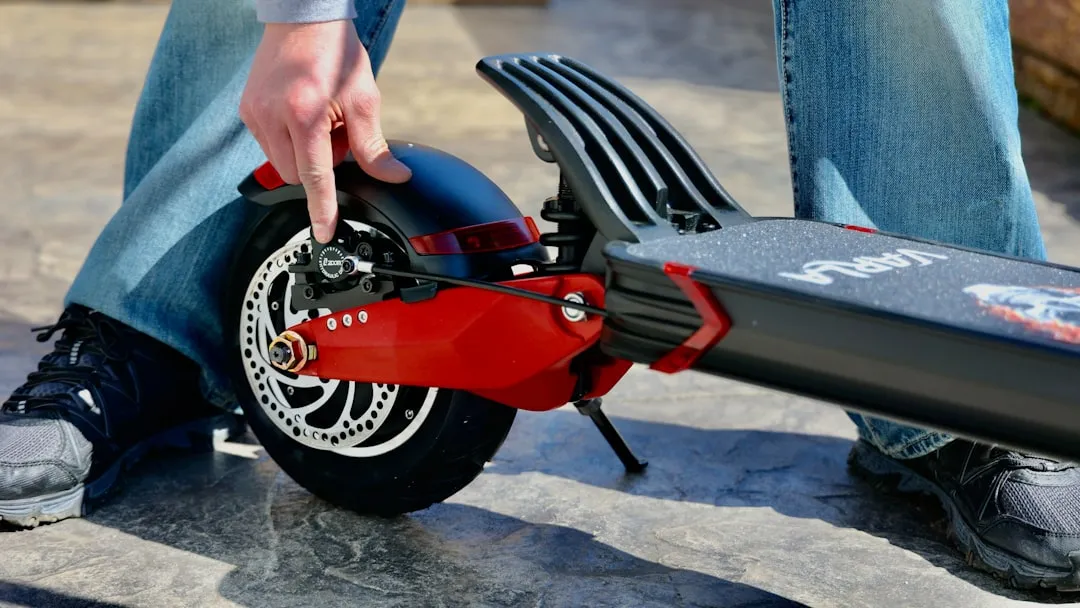 person holding red and black motorcycle